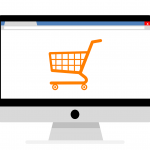 Desktop computer with orange shopping cart on screen to symbolize Woocommerce