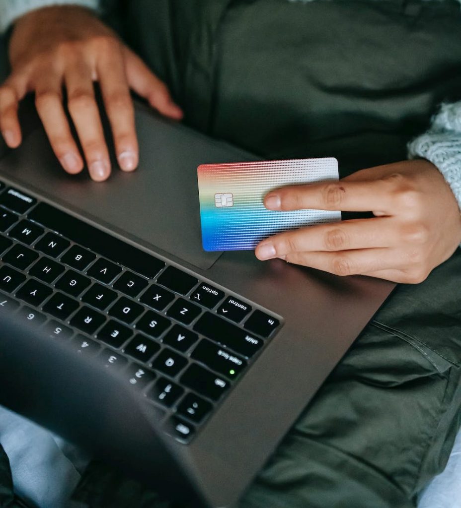 A person paying with a credit card on a laptop for merchant services online. 