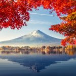 A picturesque Japanese mountain surrounded by fall leaves to symbolize Japan.