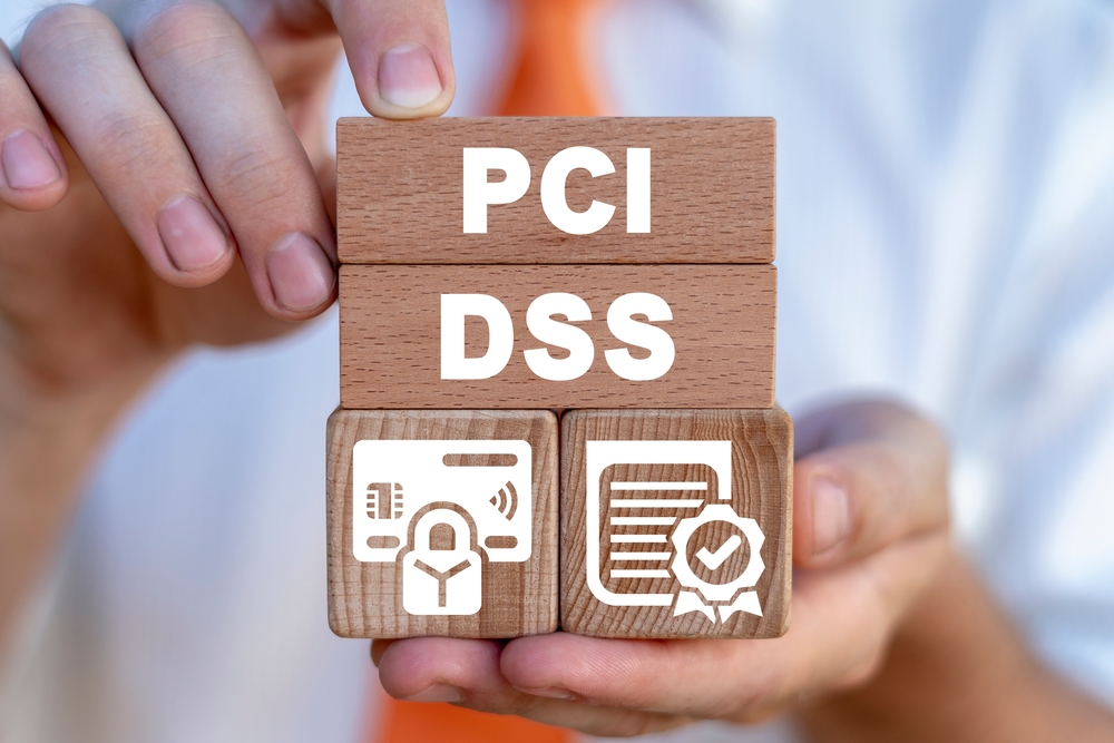 A person holding blocks that say PCI and DSS with blocks below them that have a card with a block on it and a list with a checkmark to symbolize a PCI-DSS compliant payment gateway.

