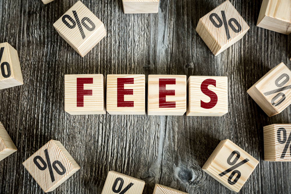 Blocks spelling out the word fees surrounded by blocks that have percent signs on them to symbolize processing fees.